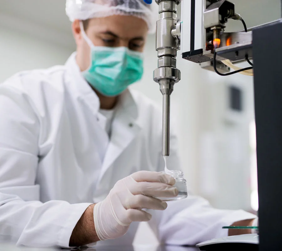 A technician filling creams in the lab