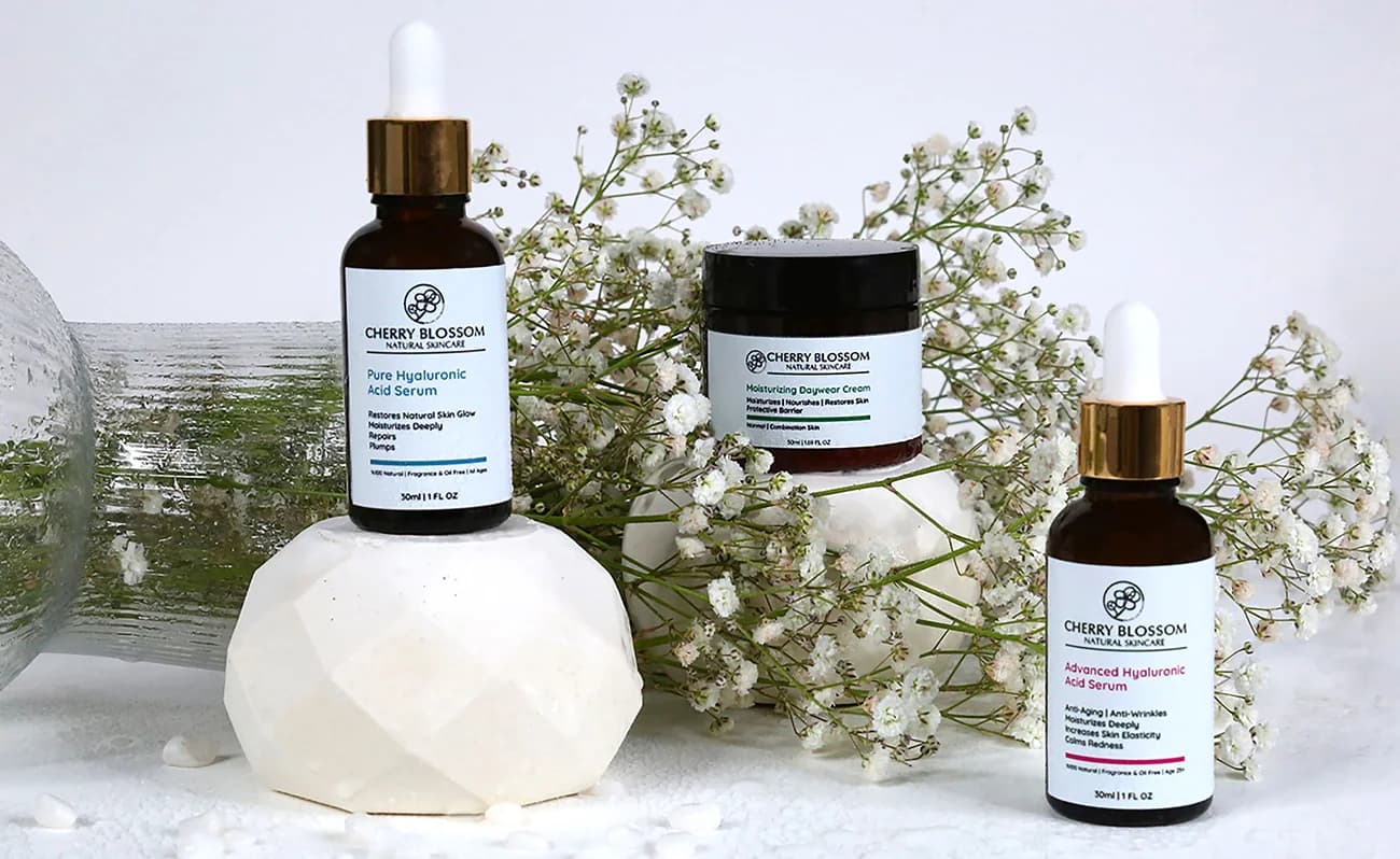 Cherry Blossom serums and a cream among white flowers